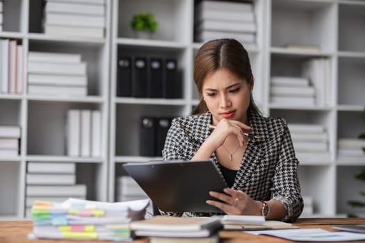 Young businesswoman has problems with her work in the office Feeling stressed and unhappy, showing a serious expression.