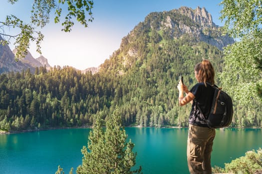 Young Attractive Woman taking a photo With her cellphone hiking in a Beautiful Lake Landscape in summer. Discovery Travel Destination Concept High quality photo