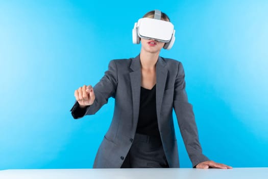 Project manager wearing VR headset and standing while holding innovation technology hologram. Skilled businesswoman connect with visual reality world while looking at data for investment. Contraption.