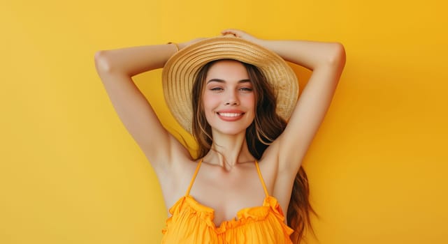Summer portrait of happy young woman in straw hat posing on yellow studio background