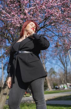 Woman with cherry flowers surrounded by blossoming trees copy space. Beauty and seasonal change and spring bloom season concept