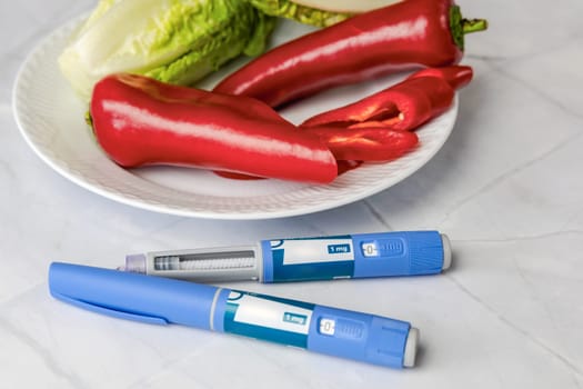 Original Danish Ozempic Insulin injection pen for diabetics and plate with vegetables. High quality photo