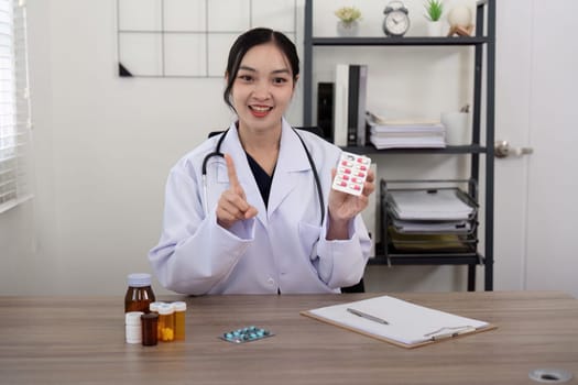 Doctor woman wearing white coat stethoscope on shoulders looking at camera, doctor make video call interact through internet talk with patient provide help online counseling and therapy concept.