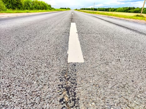 The dividing line on asphalt of the road. New white line stark against the asphalt stretches into the distance. Open Road With Painted Dividing Line