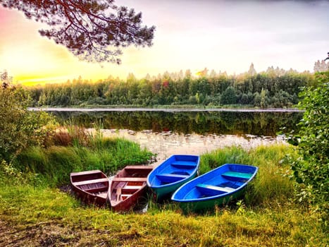 Serene Lake Shore at Sunset With Moored Rowboats. Rowboats by the lakeside during a tranquil sunset