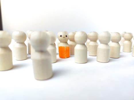 Wooden figurines with a leader and group with partial focus. The concept of distinguishing a leader from the crowd. Sighted, intelligent, different among the blind group