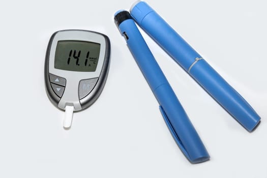 Blood sugar meter with test strips indicates high blood sugar levels and injection pen for diabetes. High quality photo