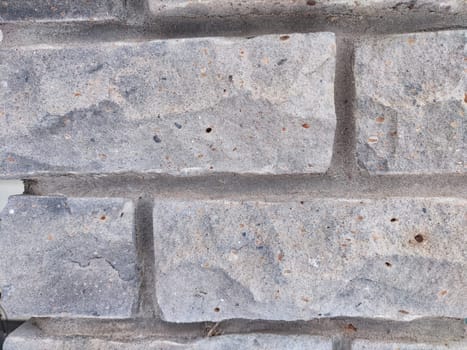 A brick wall. Background, texture. Winters Touch on a Brick Wall With Patch of Snow. Snow rests on the textured surface of a brick wall