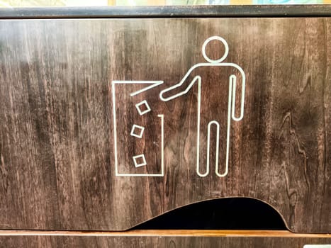 Waste Disposal Icon on a Wooden Trash Bin. A graphic of person disposing of trash