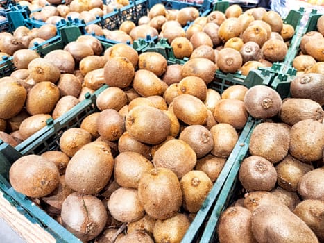 Fresh Kiwi Fruit Displayed for Sale at Market Stand. A selection of ripe kiwis in crates at a local market