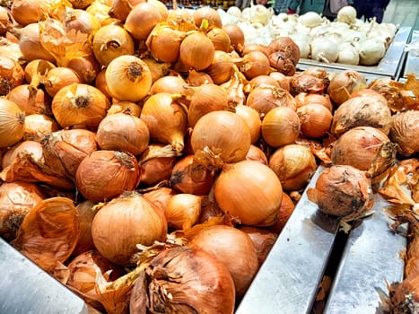 Fresh onions spread out for customers at a market. Pile of Fresh Onions for Sale at Local Market Stall