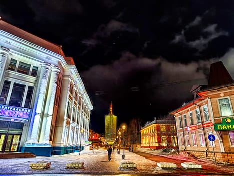 Arkhangelsk, Russia - February 28, 2024: street at night in winter. Snowy, cobblestone street adorned with lights