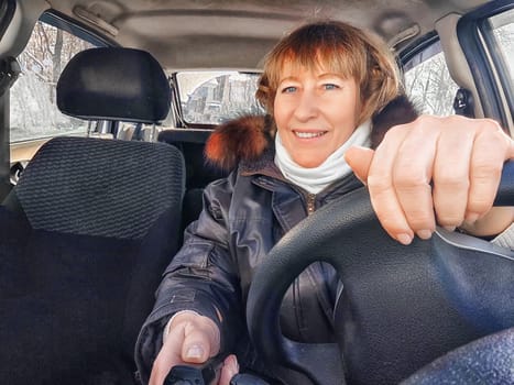 A woman in a car taking a selfie while enjoying a drive. Female driver posing inside car