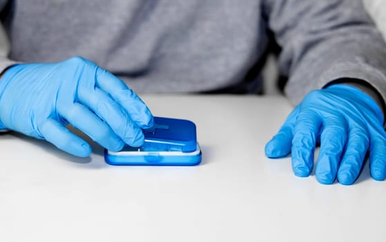 Man in surgical groves with pill organizer. High quality photo