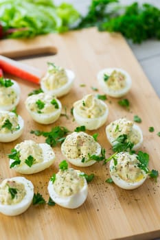 stuffed eggs, deviled eggs on a wooden table .