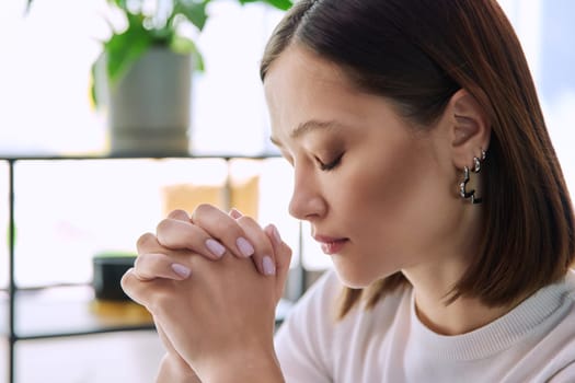 Excited sad upset serious young woman with folded hands, face in profile close-up. Emotions stress depression troubles difficulties, mental health, youth lifestyle concept