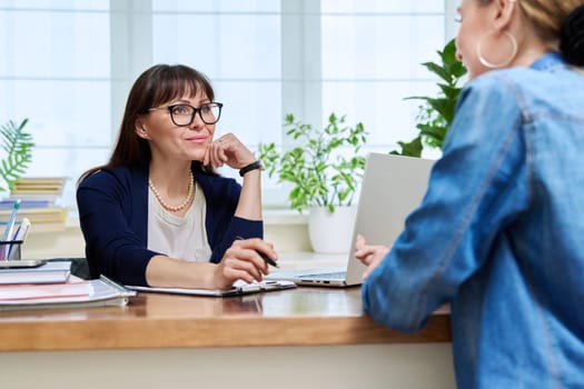 Female psychologist therapist working with young teen girl sitting in office. Teenage female student at therapy meeting with counselor. Psychology therapy psychotherapy youth mental health treatment