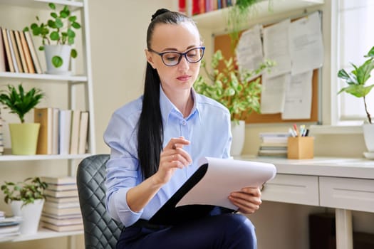 Portrait of female psychologist with clipboard at workplace in office. Professional mental therapist, counselor, psychologist, social worker. Health care service psychology psychotherapy treatment