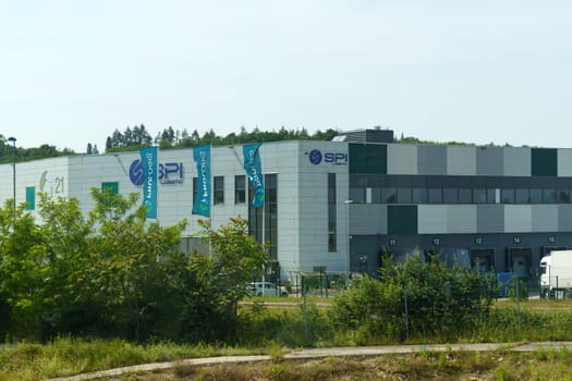 Lyon, France - May 30, 2023: Exterior view of a contemporary SPI Logistics Center with waving banners, captured on a clear day.