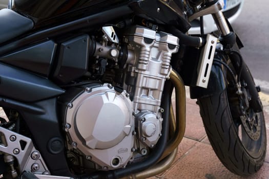 Close-up of a motorcycles engine block and exhaust pipes, showcasing the mechanical details and design.
