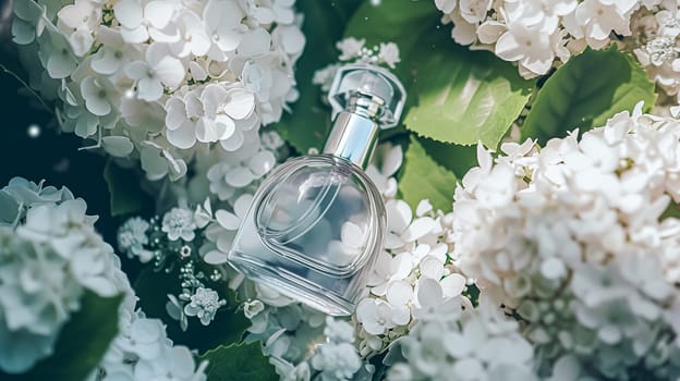 Perfume bottle in flowers, fragrance on blooming background, floral scent and cosmetic product idea