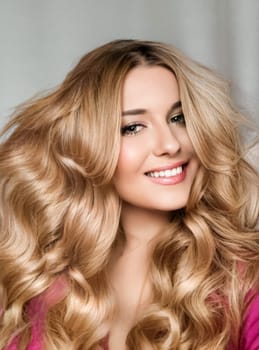 Beautiful blonde woman with curly volume hairstyle, long luxurious hair and beauty makeup, glamorous look face portrait for luxury fashion and natural cosmetics idea