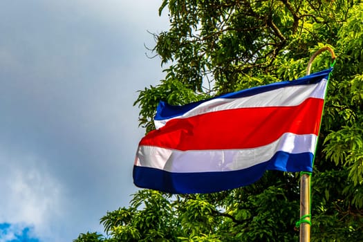 Costa Rican flag with blue sky background in Alajuela Costa Rica in Central America.