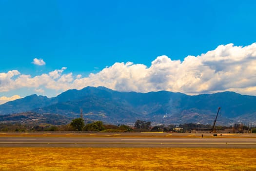 Runway airport and city mountains panorama view from airplane in Rio Segundo Alajuela Costa Rica in Central America.