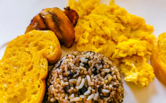 Typical Costa Rican food dish Rice Banana Scrambled eggs Beans and bread in Alajuela Costa Rica in Central America.