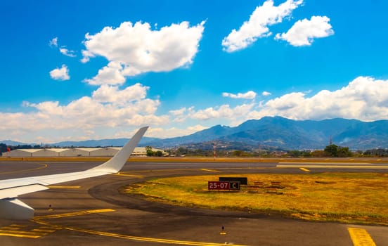 Runway airport and city mountains panorama view from airplane in Rio Segundo Alajuela Costa Rica in Central America.