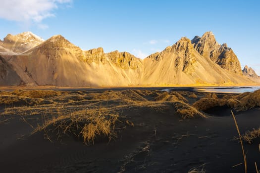 Northern grace along coastline and glorious Vestrahorn mountains in Iceland. Famous Stokksnes seashore with icelandic beach and Scandinavian surroundings, natural arctic skyline with rocky hills.