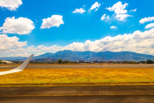 Runway airport and city mountains panorama view from airplane in Rio Segundo Alajuela Costa Rica in Central America.