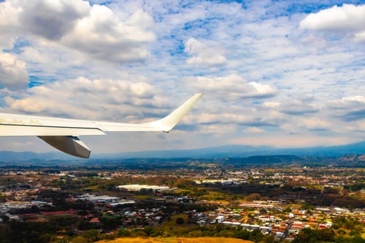 Runway airport and city mountains panorama view from airplane in Rio Segundo Alajuela Costa Rica in Central America.