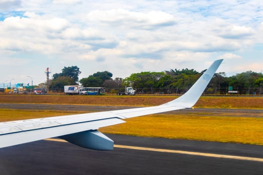 Runway airport and city mountains panorama view from airplane in Rio Segundo Alajuela Costa Rica in Central America.