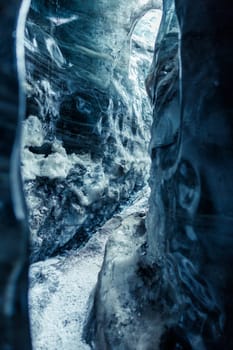 Beautiful ice formations in vatnajokull crevasse, massive blue icy rocks of melting frozen structure. Global warming affecting icelandic glaciers and icebergs, destroying ice caves.