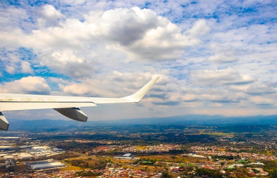 Runway airport and city mountains panorama view from airplane in Rio Segundo Alajuela Costa Rica in Central America.