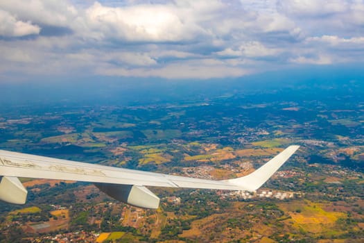 Runway airport and city mountains panorama view from airplane in Rio Segundo Alajuela Costa Rica in Central America.