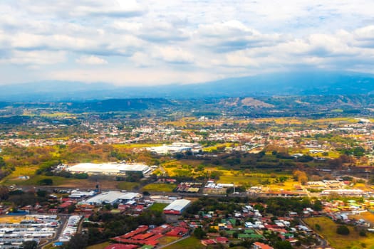 Runway airport and city mountains panorama view from airplane in Rio Segundo Alajuela Costa Rica in Central America.