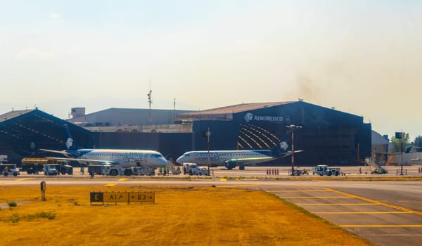 Aircraft at the airport Building and runway Aeropuerto Internacional Benito Juarez in Penon de los Banos Venustiano Carranza Mexico City Mexico.