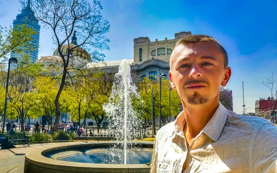 Male traveler man person selfie in front of the palace of fine arts an architectural masterpiece in the center of Mexico City in Mexico.