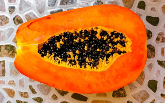 Half papaya in hand with background in Playa del Carmen Quintana Roo Mexico.