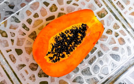 Half papaya in hand with background in Playa del Carmen Quintana Roo Mexico.