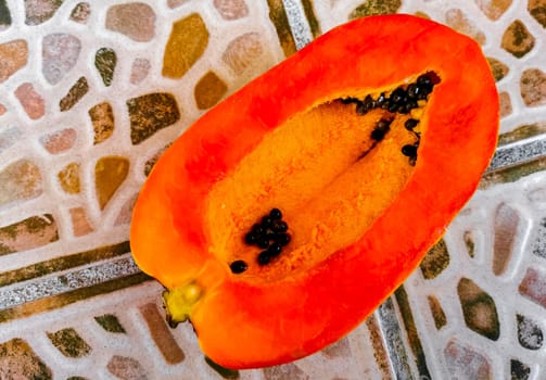 Half papaya in hand with background in Playa del Carmen Quintana Roo Mexico.