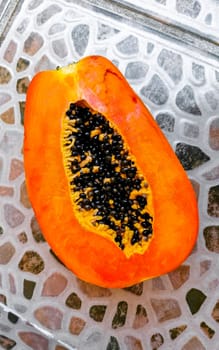 Half papaya in hand with background in Playa del Carmen Quintana Roo Mexico.