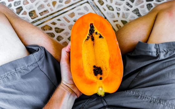 Half papaya in hand with background in Playa del Carmen Quintana Roo Mexico.