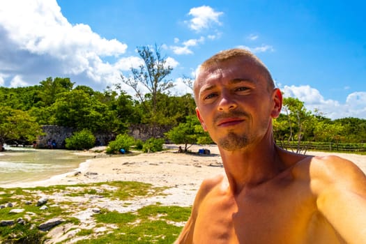 Male tourist Travelling man taking selfie photo on the beach in Playa del Carmen Quintana Roo Mexico.