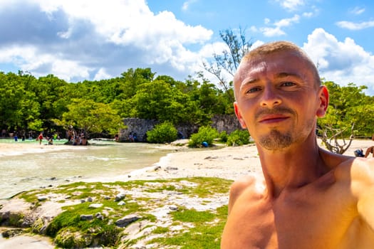 Male tourist Travelling man taking selfie photo on the beach in Playa del Carmen Quintana Roo Mexico.