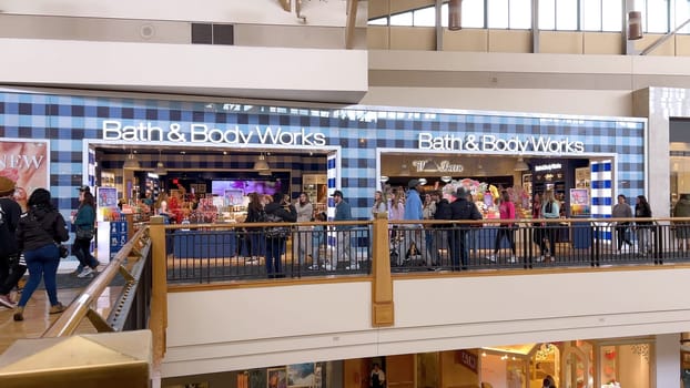 Denver, Colorado, USA-April 28, 2024- Capturing the expansive and airy interior of Park Meadows Mall, this image highlights the modern architectural style with wooden beams, large hanging lights, and a series of vibrant hanging ribbons, creating a lively shopping atmosphere.