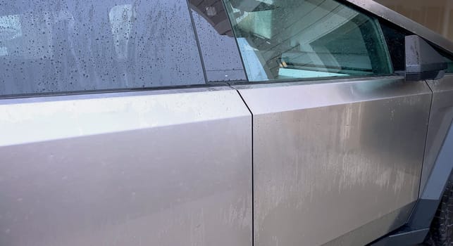 Denver, Colorado, USA-April 28, 2024- This image captures a Tesla Cybertruck undergoing a thorough cleaning, focusing on the high-pressure washing of its cargo bed, demonstrating the maintenance of its durable and robust design. High-Pressure Cleaning of the Tesla Cybertruck Cargo Bed. High quality photo