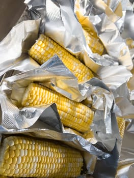 This image showcases fresh corn on the cob, neatly arranged in vacuum-sealed plastic packaging to preserve its freshness and flavor, ready for distribution or sale.